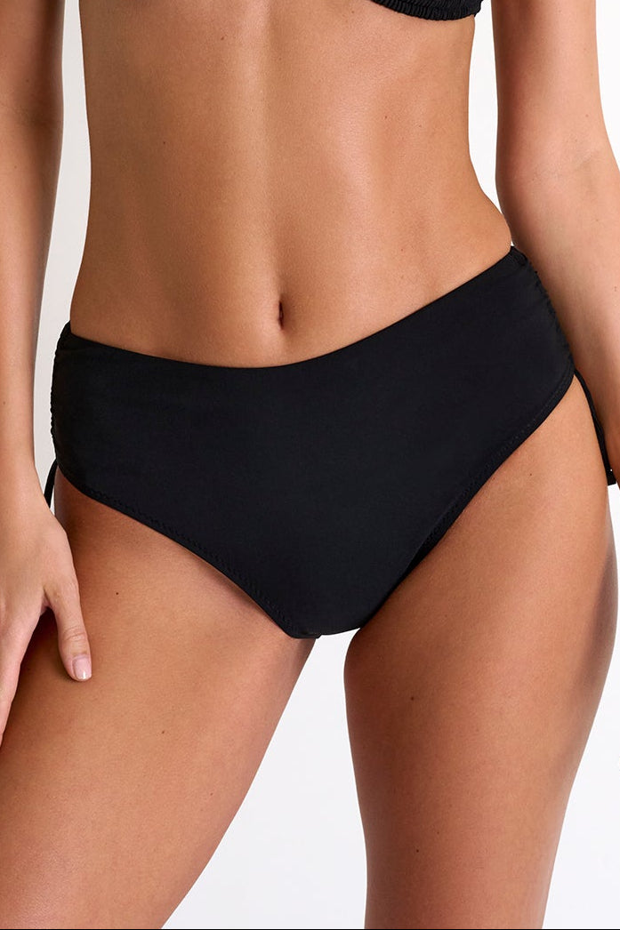 Woman wearing a black bikini against a plain background