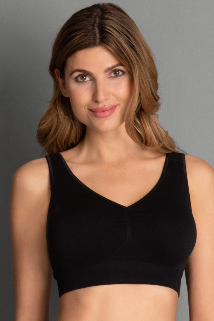 Woman wearing a black wireless bra against a gray background