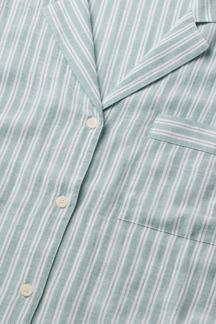 Close-up of a light green and white striped shirt with buttons and a pocket