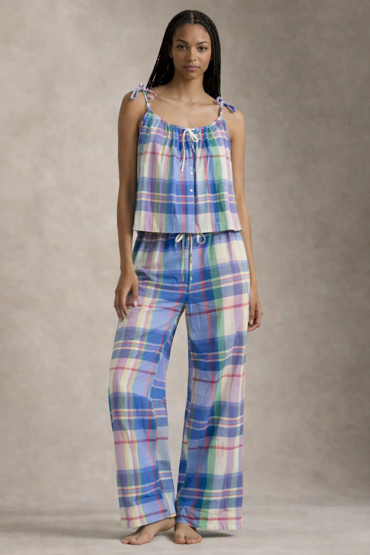Woman wearing a plaid pajama set against a neutral background