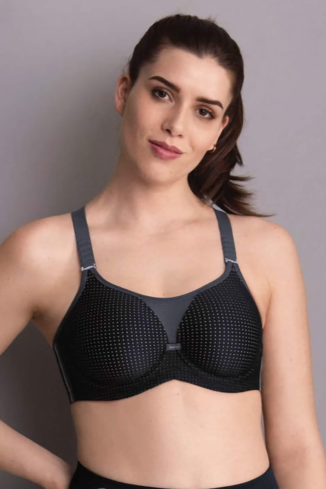 Woman wearing a black sports bra against a gray background