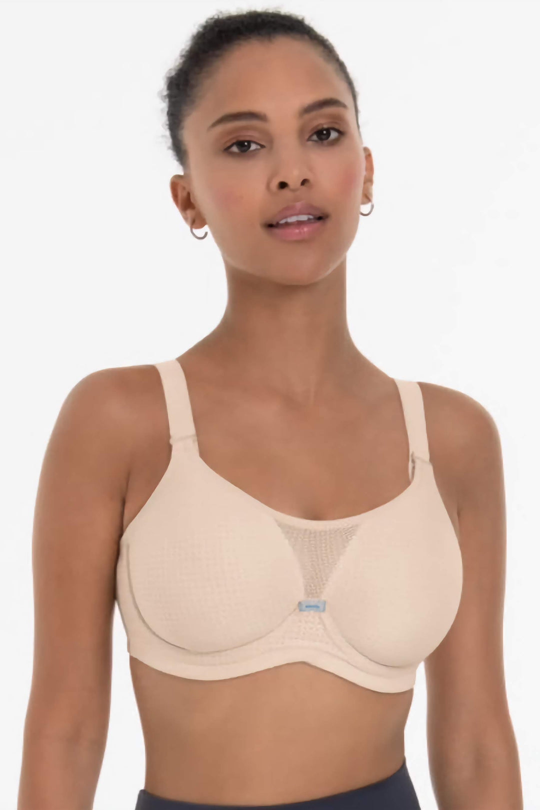 Woman wearing a beige sports bra on a white background
