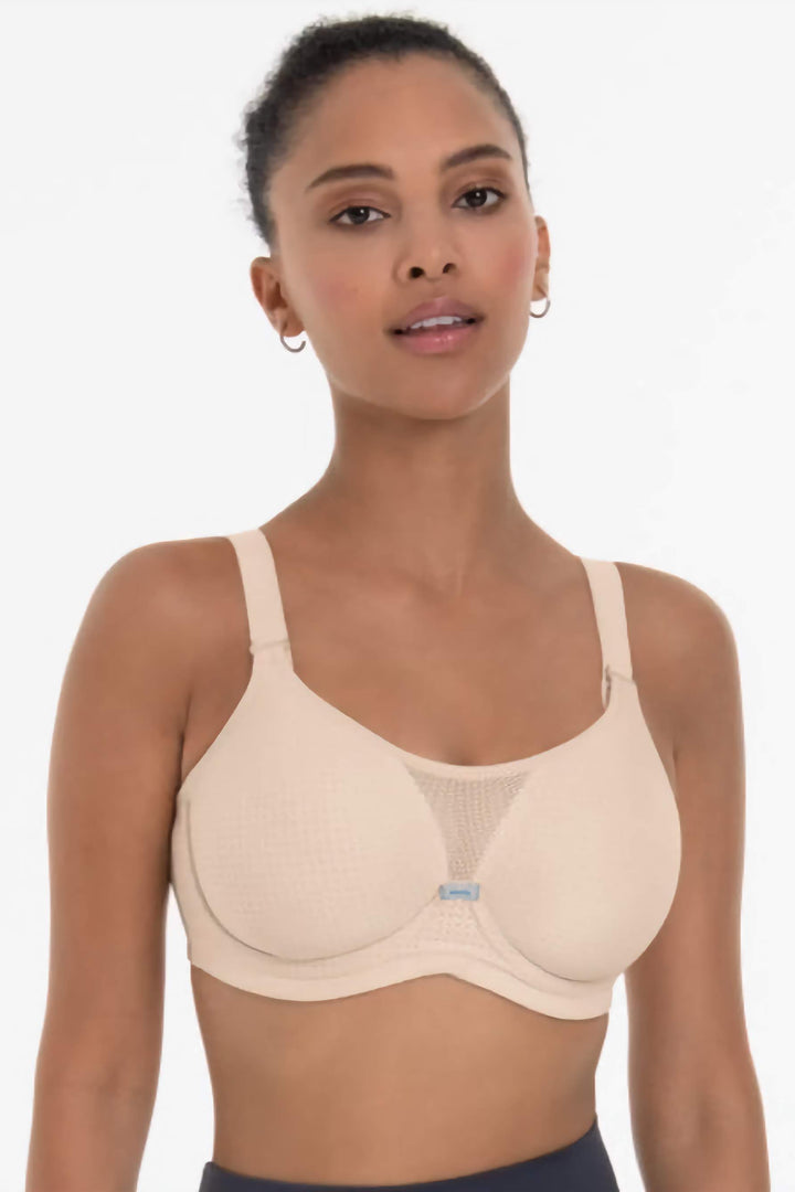 Woman wearing a beige sports bra on a white background