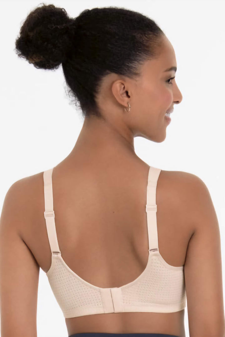 Woman wearing a beige sports bra on a white background
