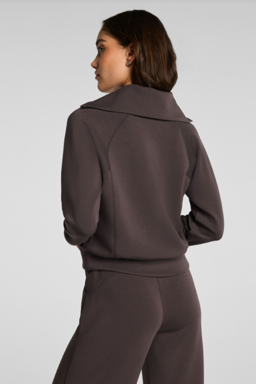 Woman wearing a brown tracksuit on a white background