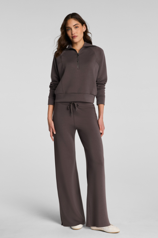 Woman wearing a brown tracksuit on a light gray background