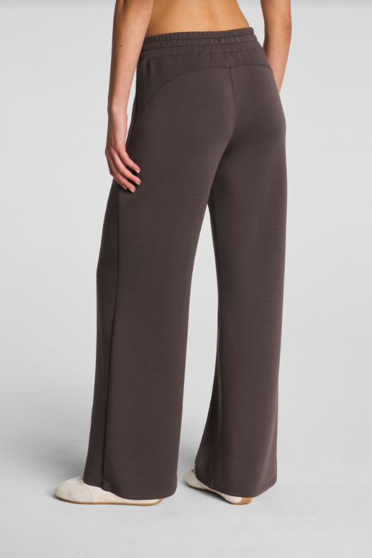 Brown wide-leg pants worn by a person on a gray background