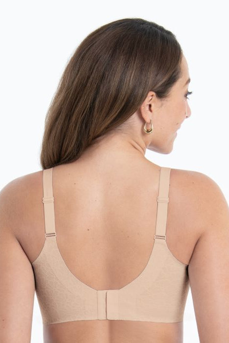 Woman wearing a beige bralette with back closure on a white background