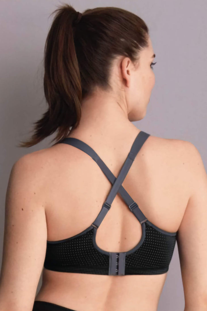 Woman wearing a black sports bra against a gray background