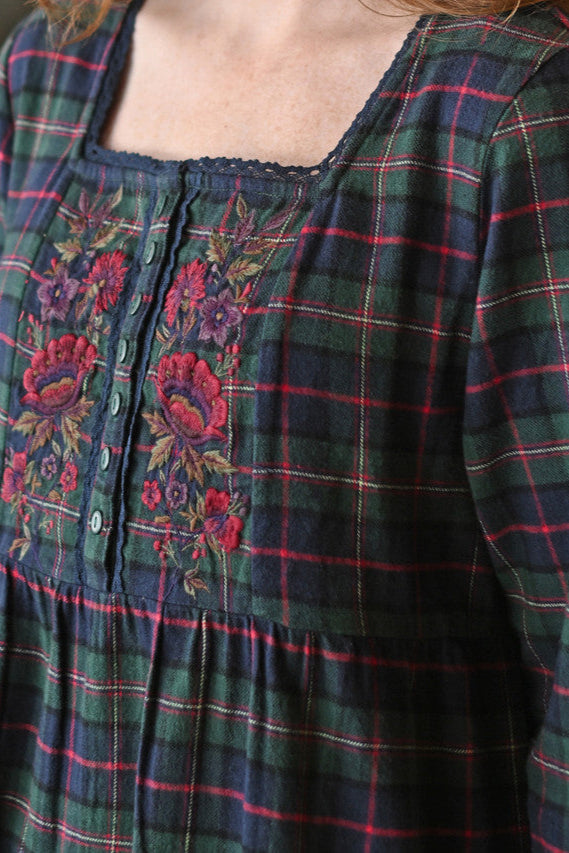 Plaid nightdress with floral embroidery on a blurred background