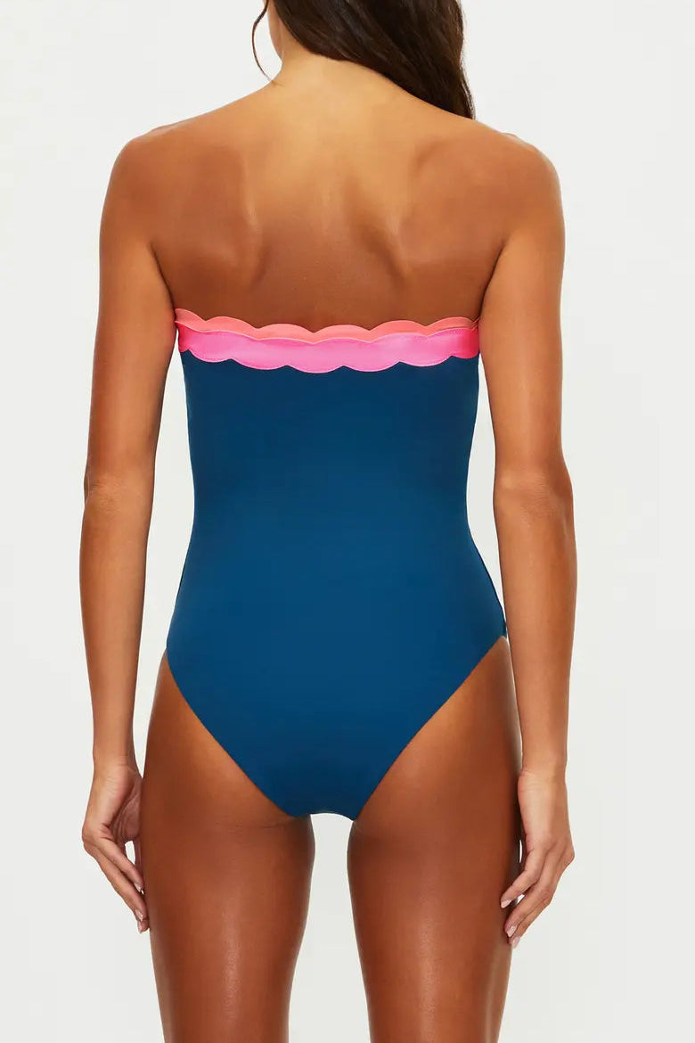 Blue strapless swimsuit with pink scalloped edge on a white background
