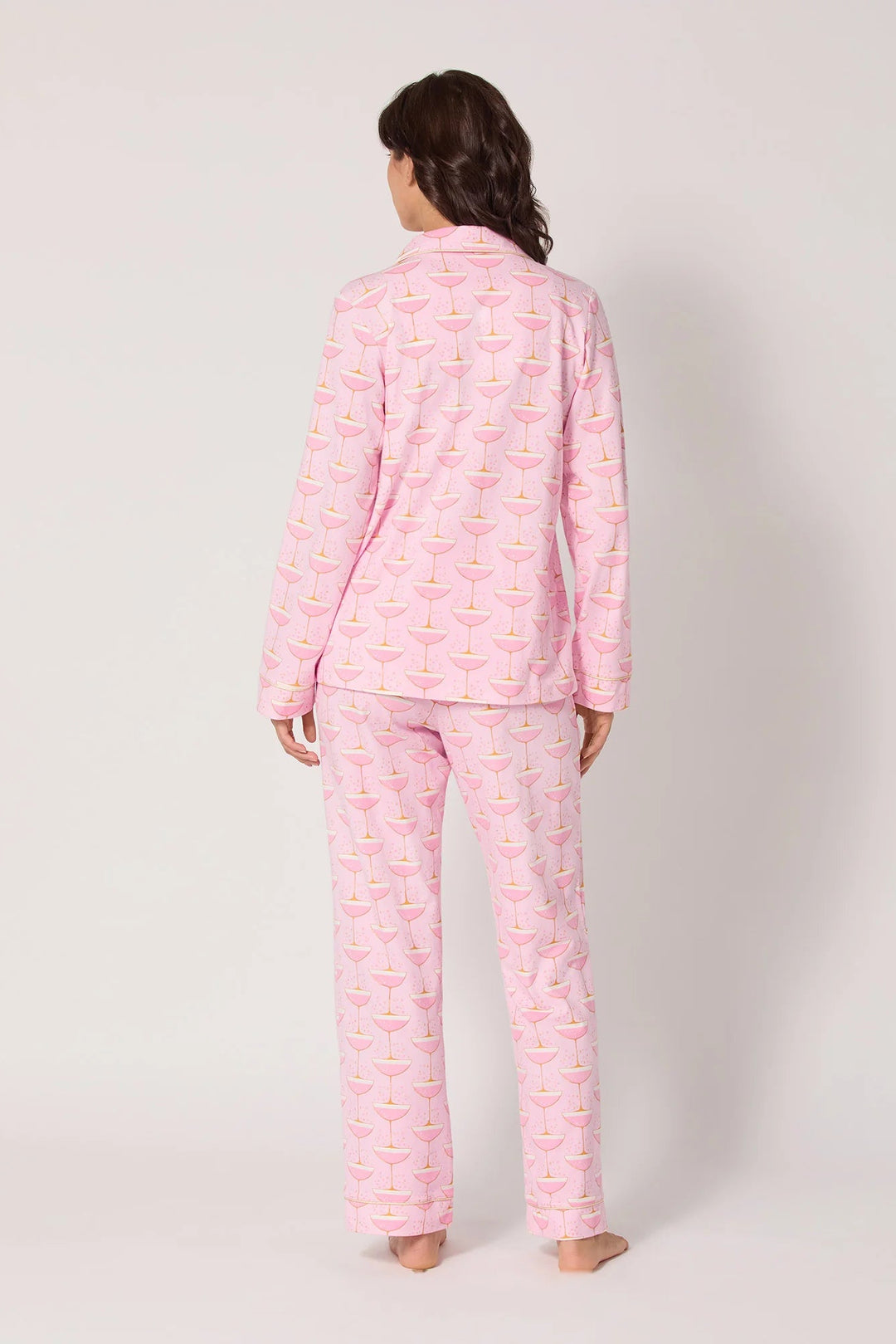 Person wearing pink pajama set with a pattern on a white background