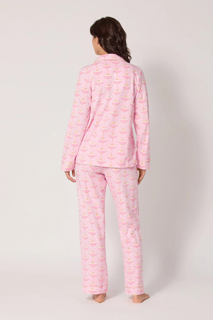 Person wearing pink pajama set with a pattern on a white background