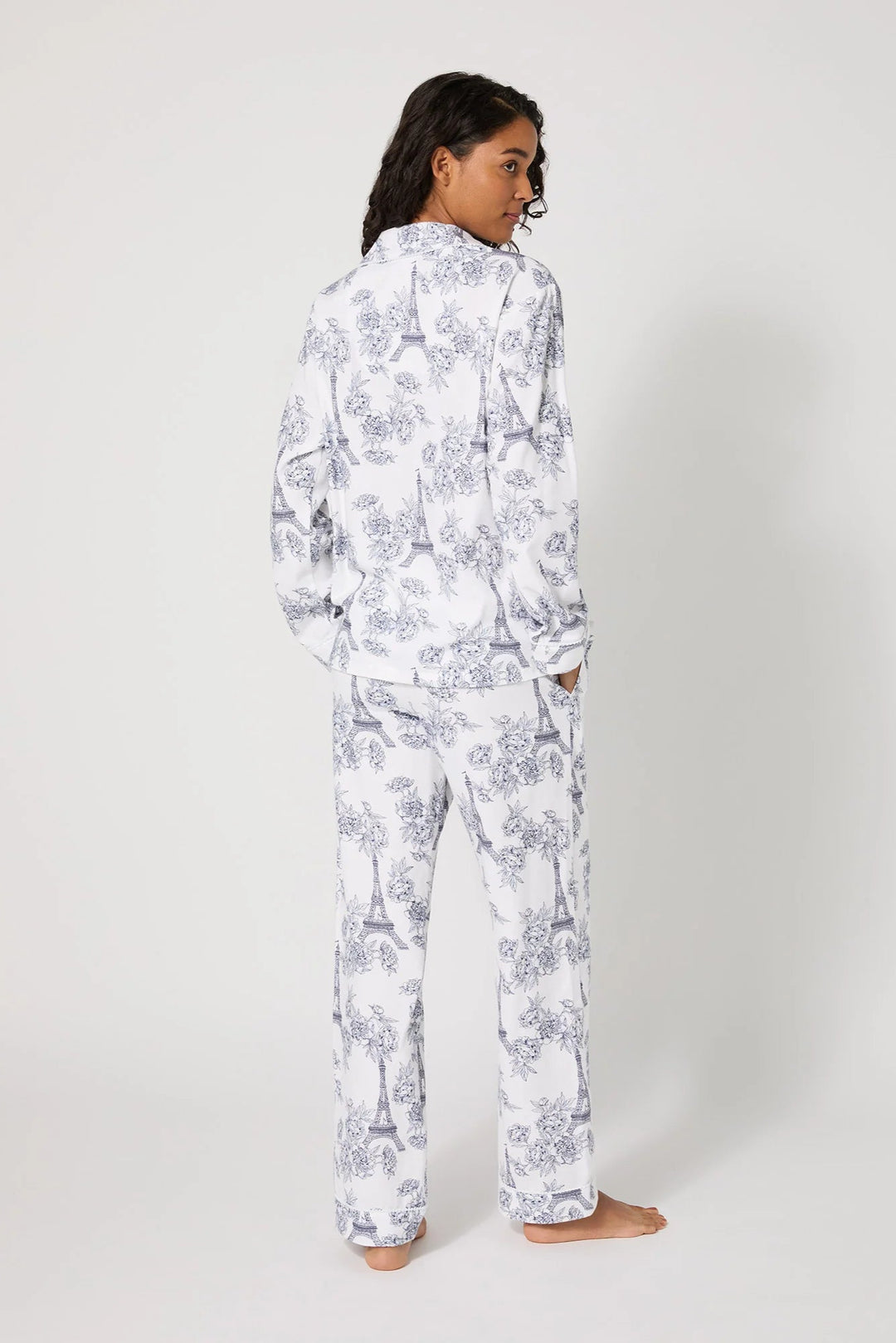 Person wearing a white floral pajama set on a white background