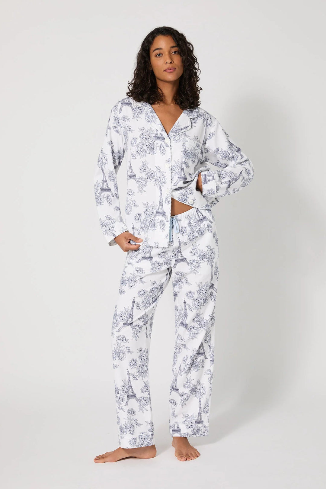 Woman wearing a white floral pajama set on a white background