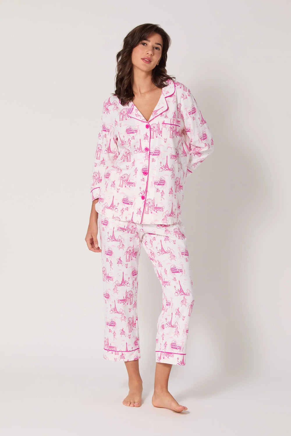 Woman wearing a pink and white pajama set on a white background
