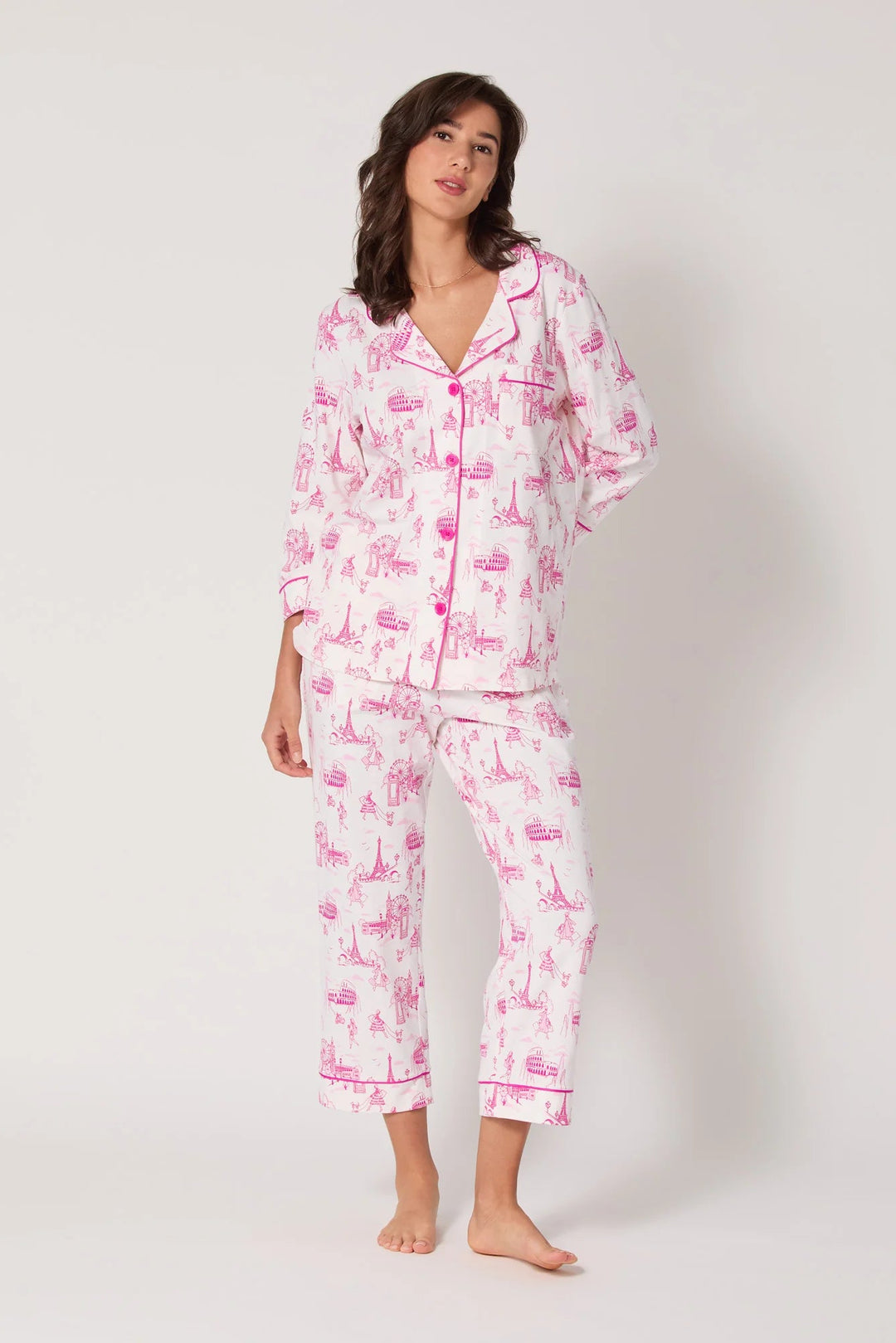 Woman wearing a pink and white pajama set on a white background