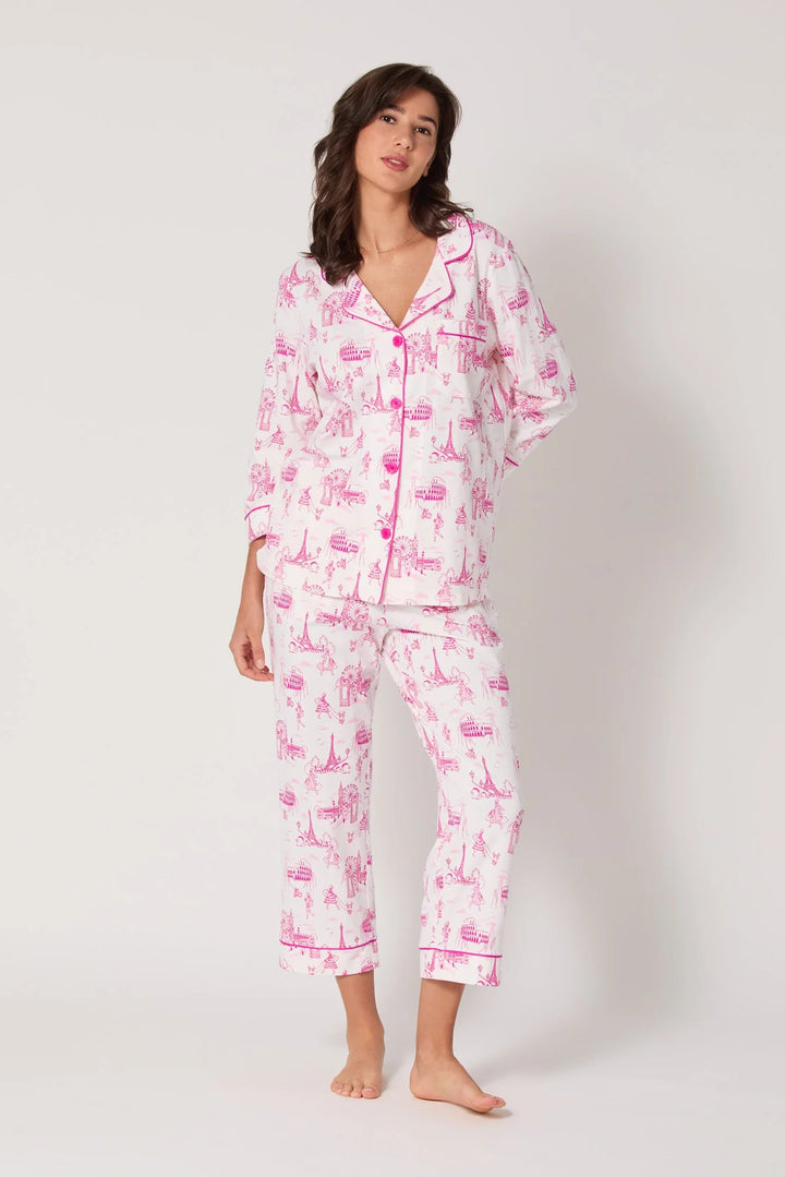 Woman wearing a pink and white pajama set on a white background
