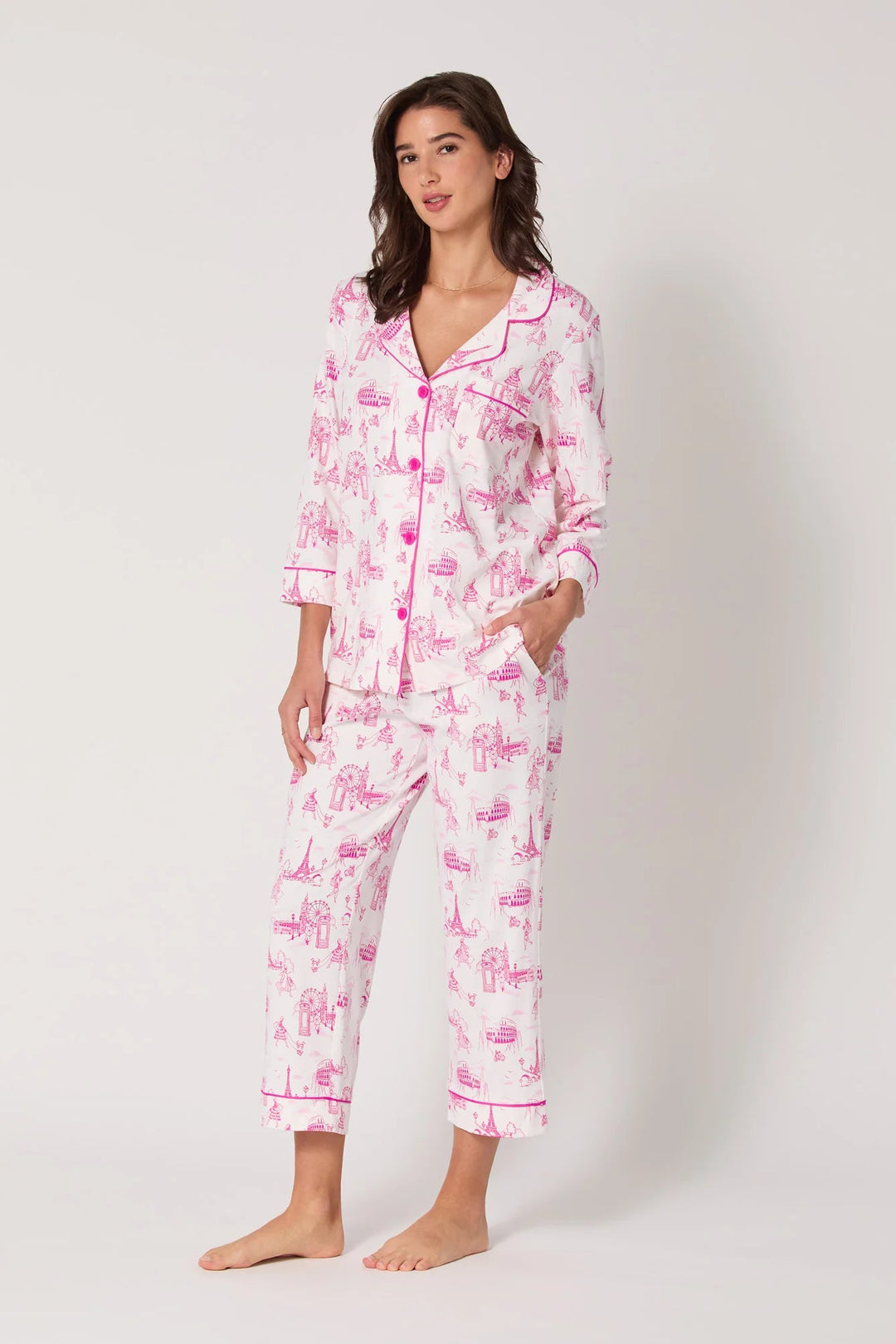 Woman wearing a pink and white pajama set with a pattern on a white background