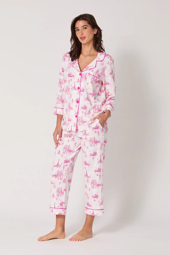 Woman wearing a pink and white pajama set with a pattern on a white background