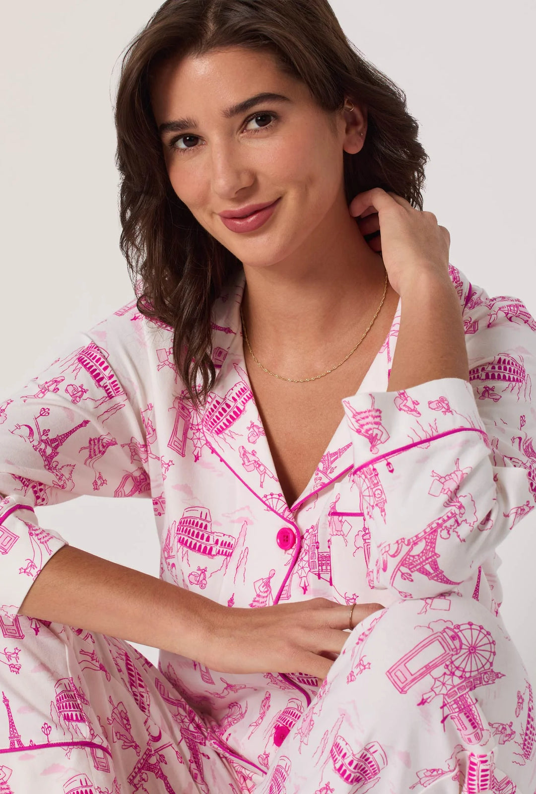 Woman wearing a white pajama set with pink graphics on a white background