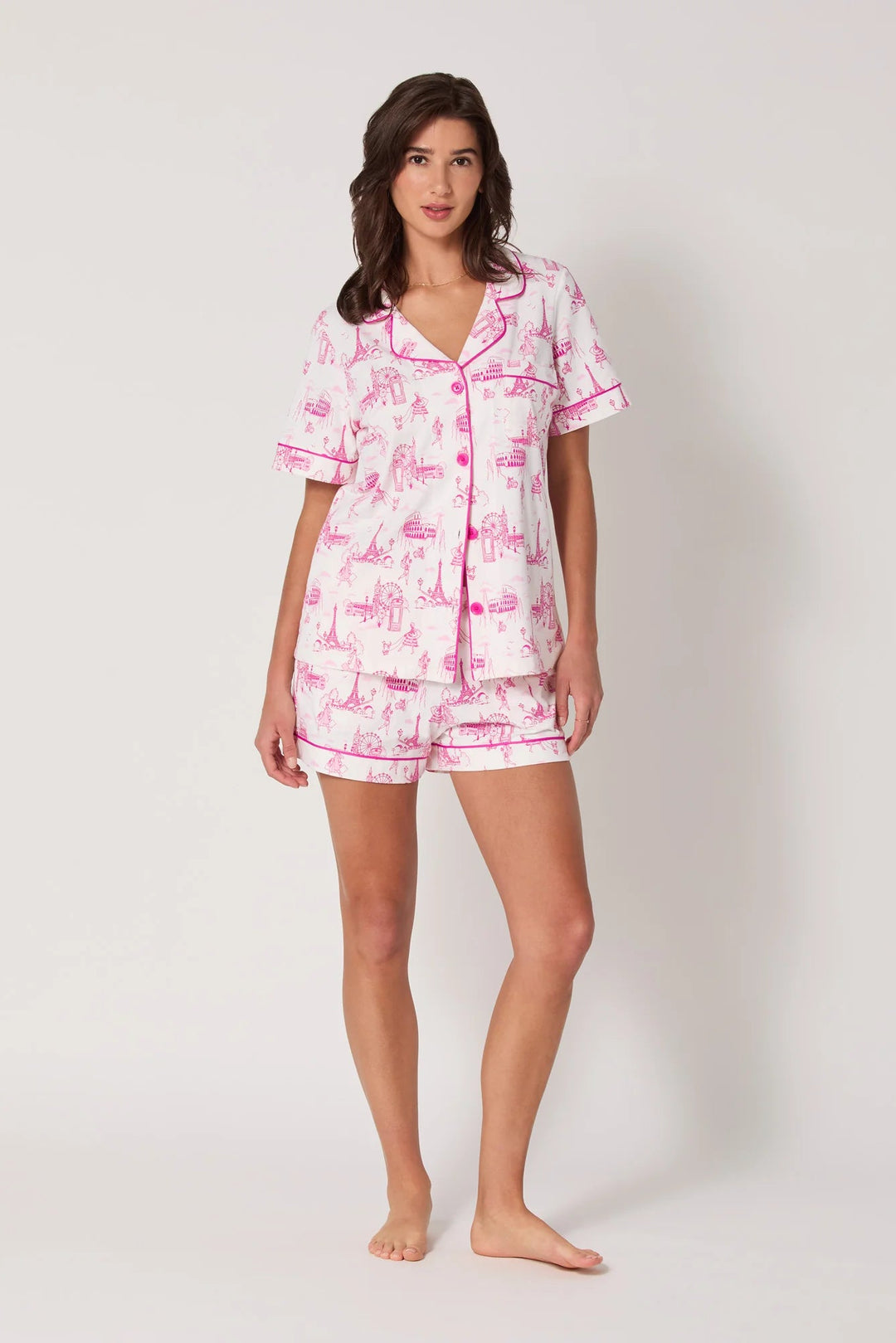 Woman wearing a pink and white pajama set on a plain background