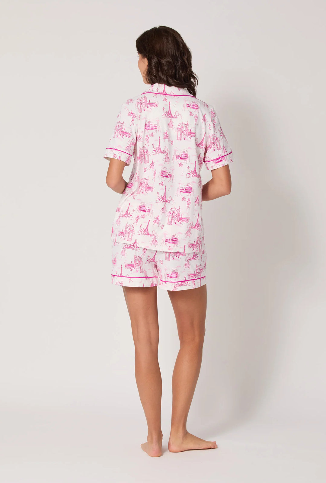 Person wearing a pink and white pajama set with a pattern on a white background