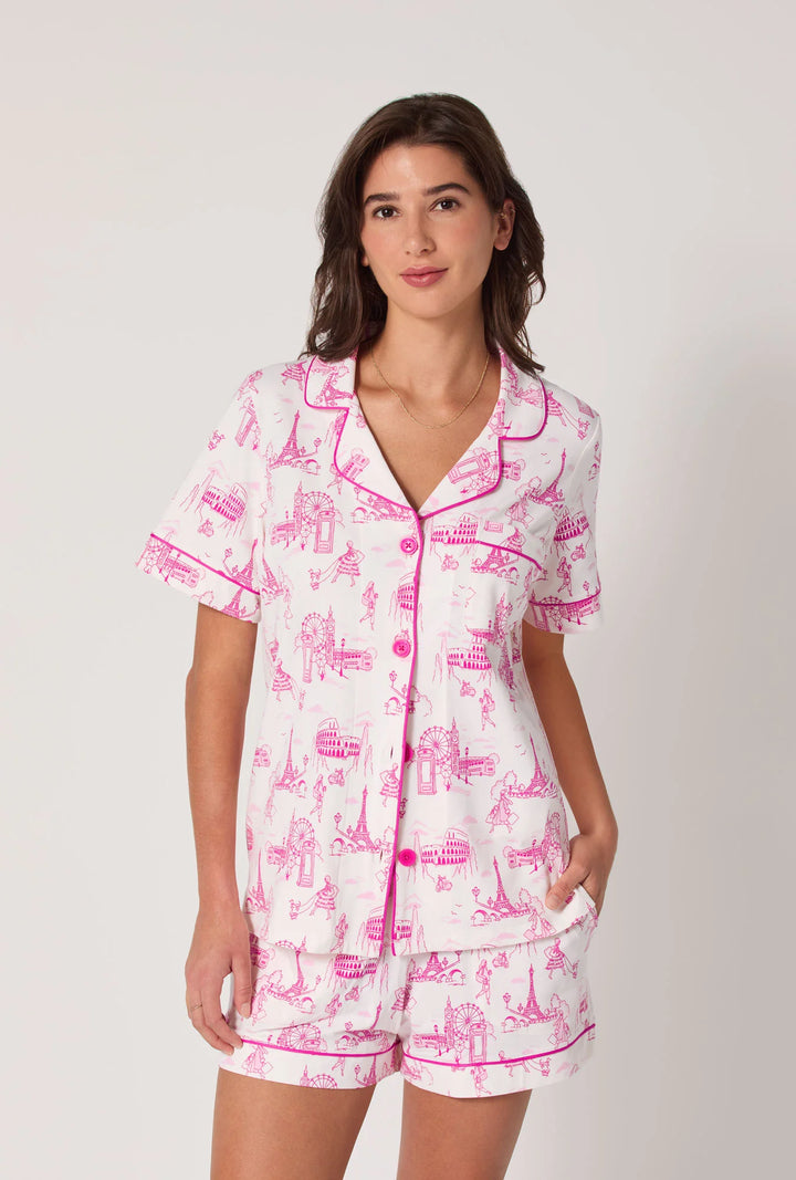 Woman wearing a pink and white pajama set on a plain background
