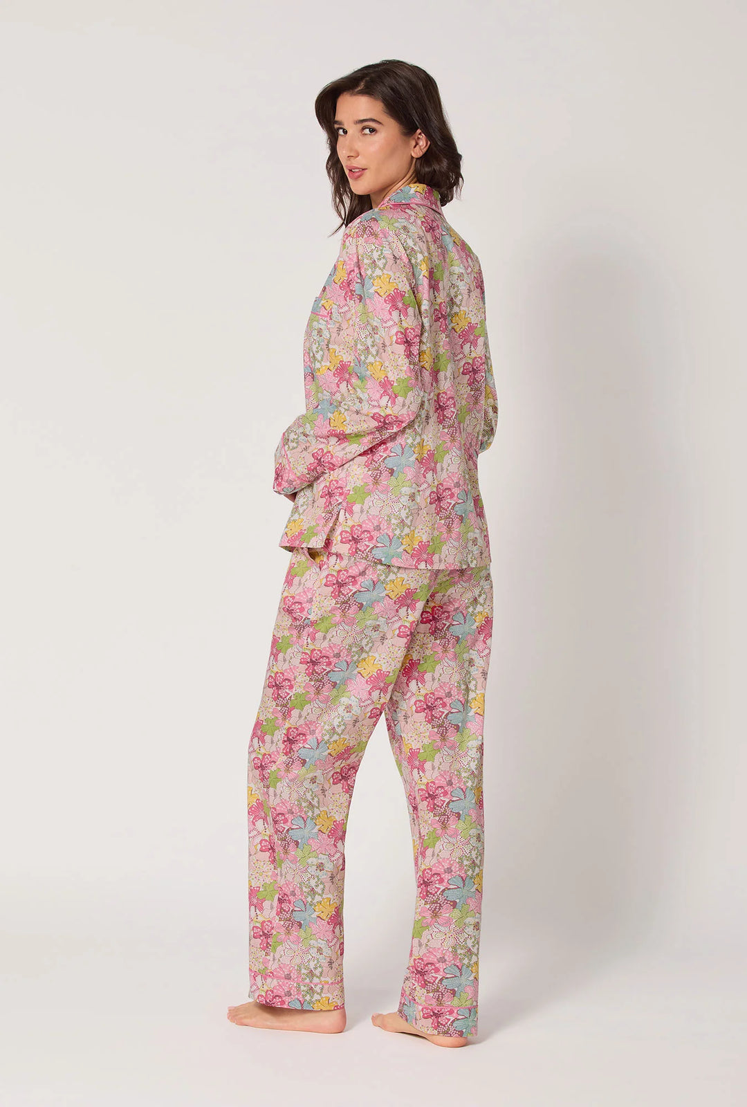 Woman wearing a floral pajama set on a white background
