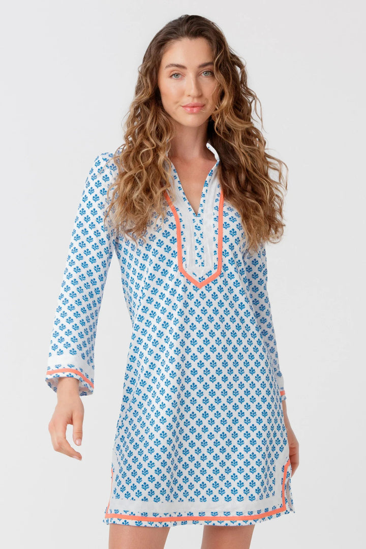 Woman wearing a blue patterned dress with white background