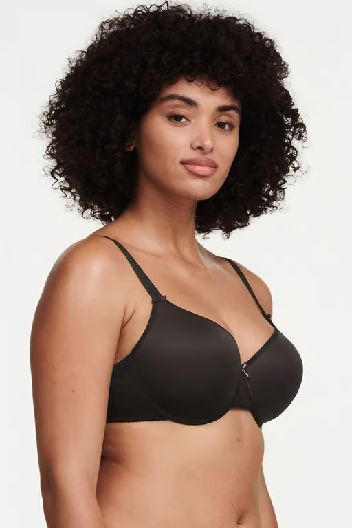 Woman wearing a black t-shirt bra against a plain background