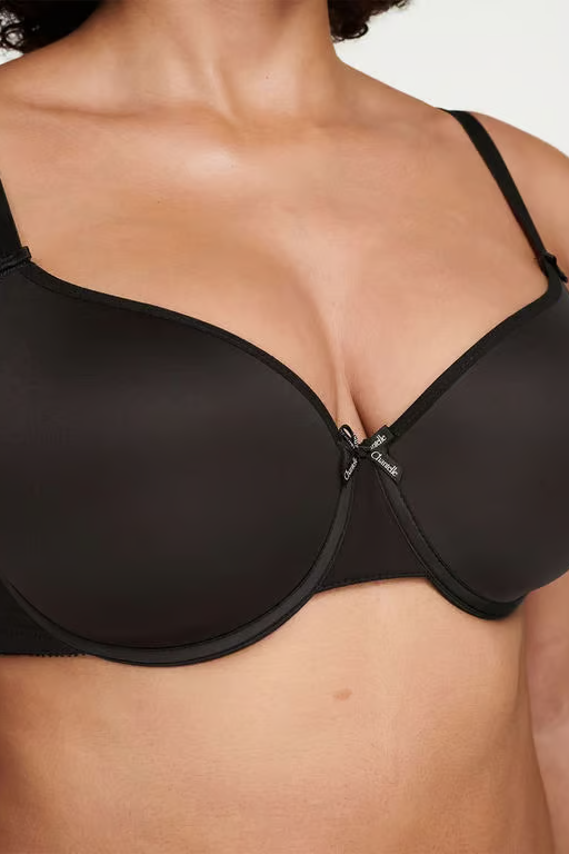 Black bra worn by a person on a white background