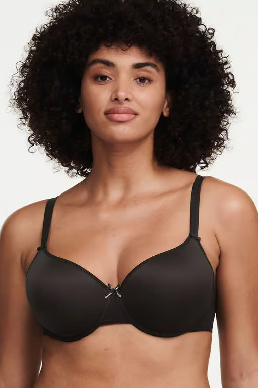 Woman wearing a black t-shirt bra against a plain background