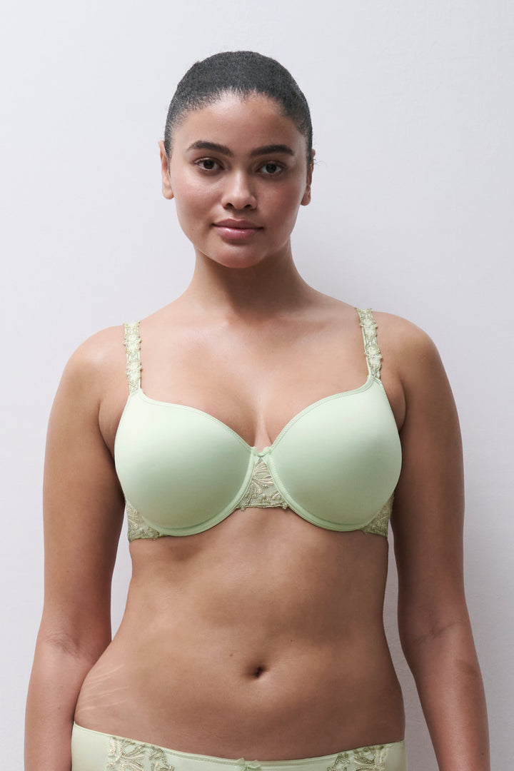 Woman wearing a light green bra and panties set against a plain background