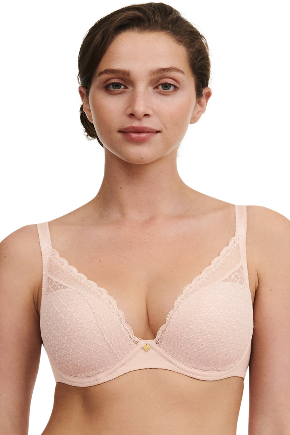 Woman wearing a beige Chantelle plunge bra with lace. Seamless and smooth bra with comfortable and exellent fit and racerback hook.