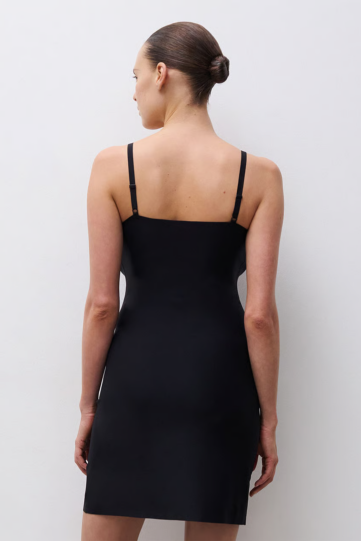 Woman wearing a black slip against a white background