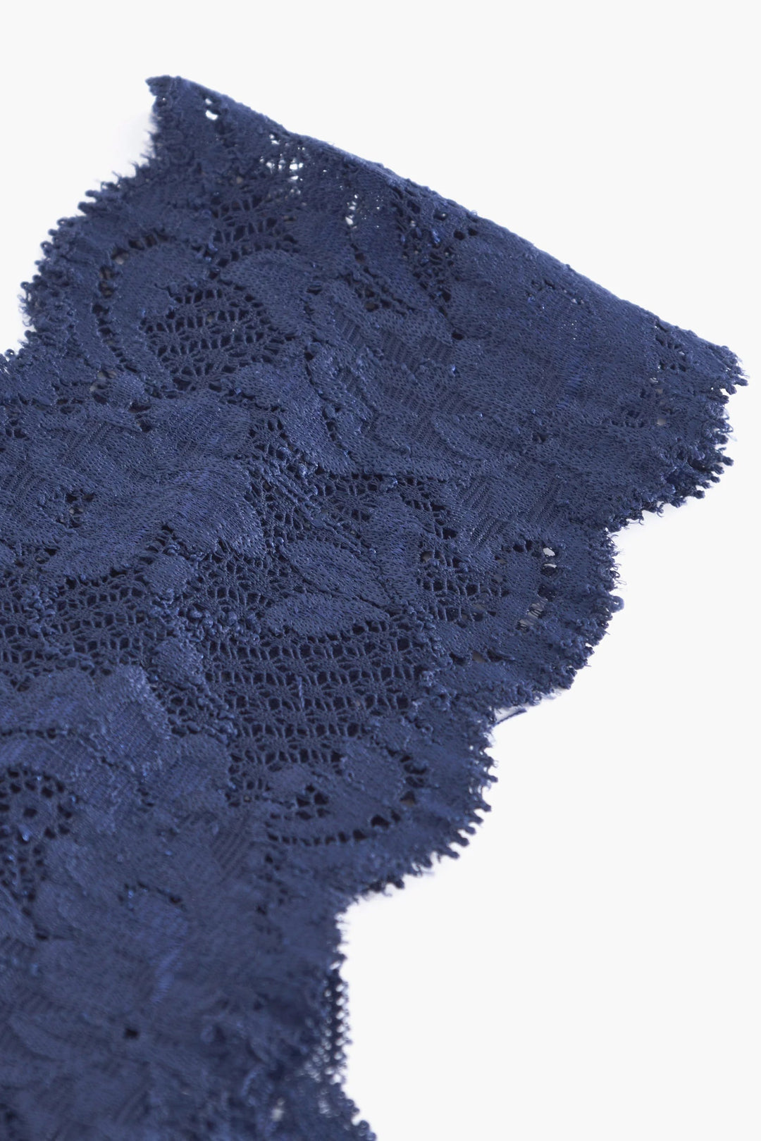 Close-up of navy blue lace fabric on a white background