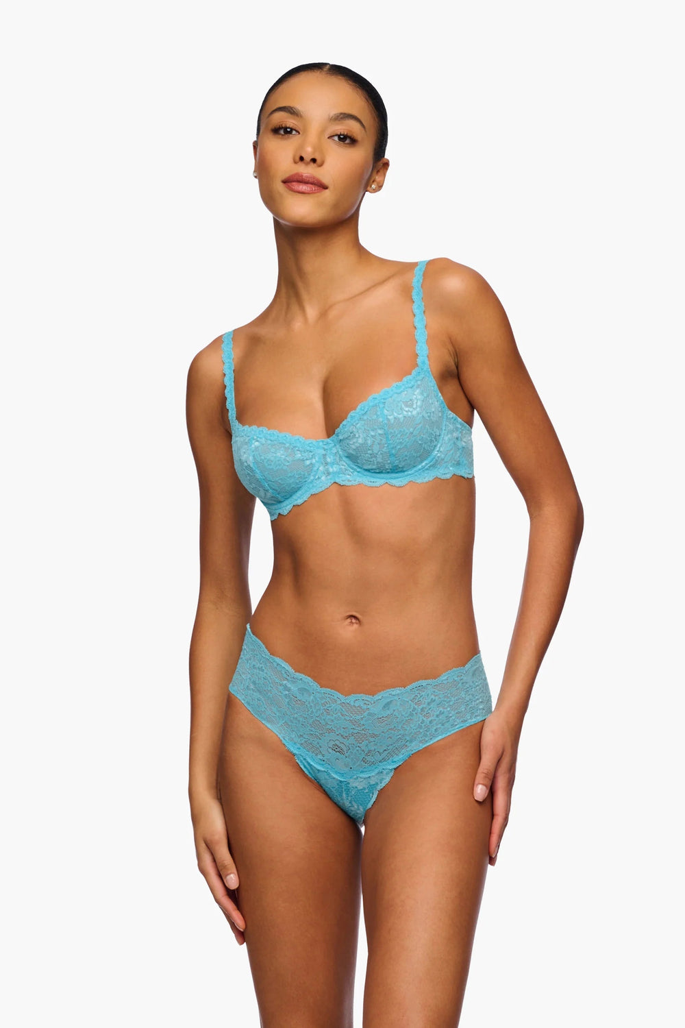 Woman wearing a blue lace lingerie set on a white background