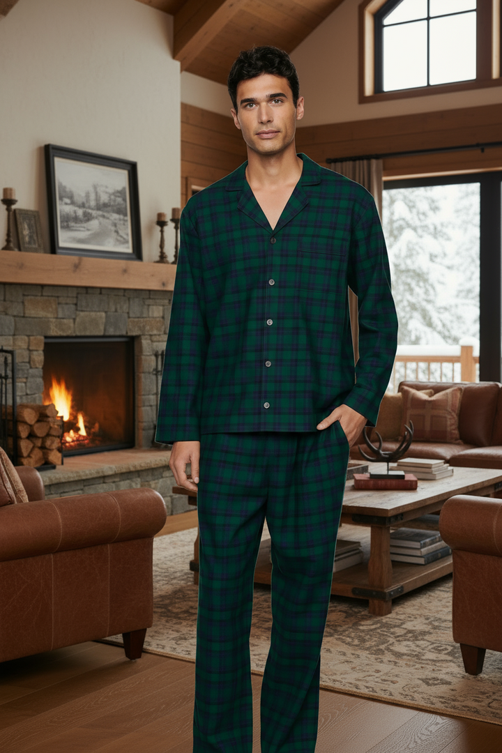 Man wearing green plaid pajamas in a cozy living room with a fireplace.