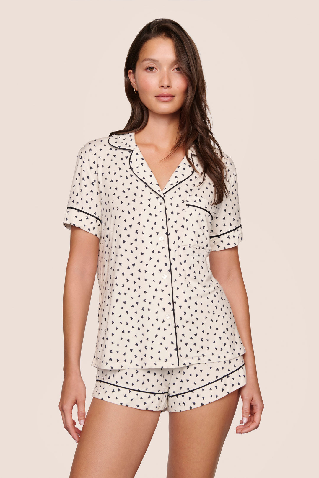 Woman wearing a polka dot pajama set on a beige background