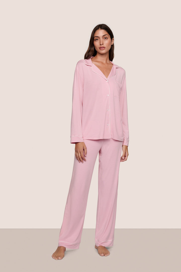 Woman wearing pink pajamas against a plain background