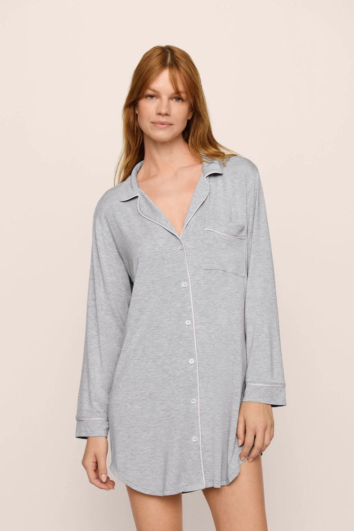 Woman wearing a gray button-up shirt dress against a beige background