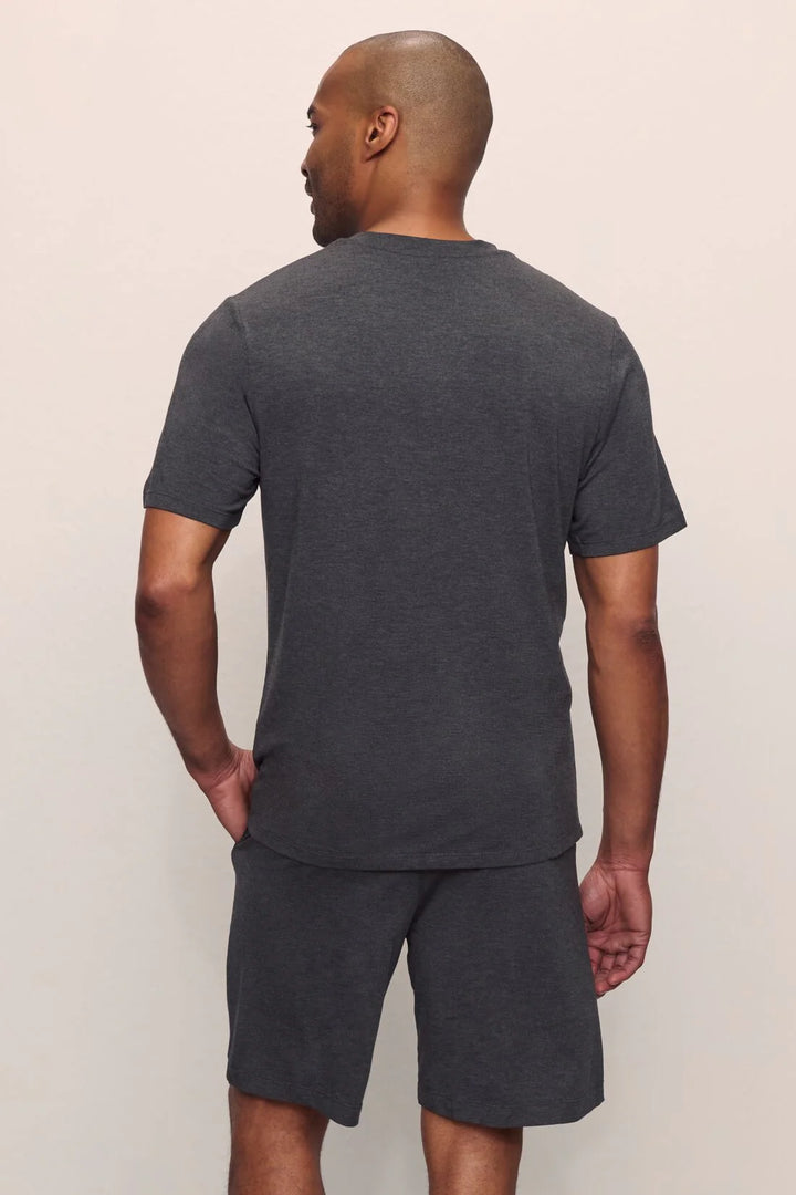 Man wearing a dark gray t-shirt and shorts mens pj set against a plain background