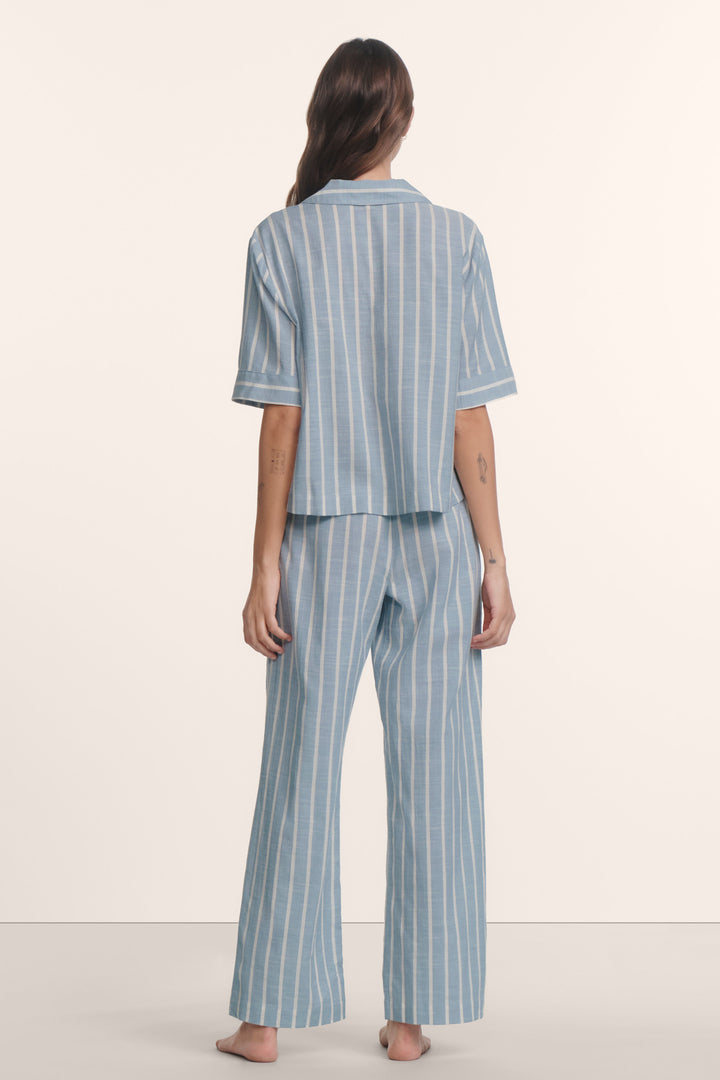 Woman wearing an eberjey blue and white striped nautico pajama set. Short sleeve boxy top and wide leg pants.
