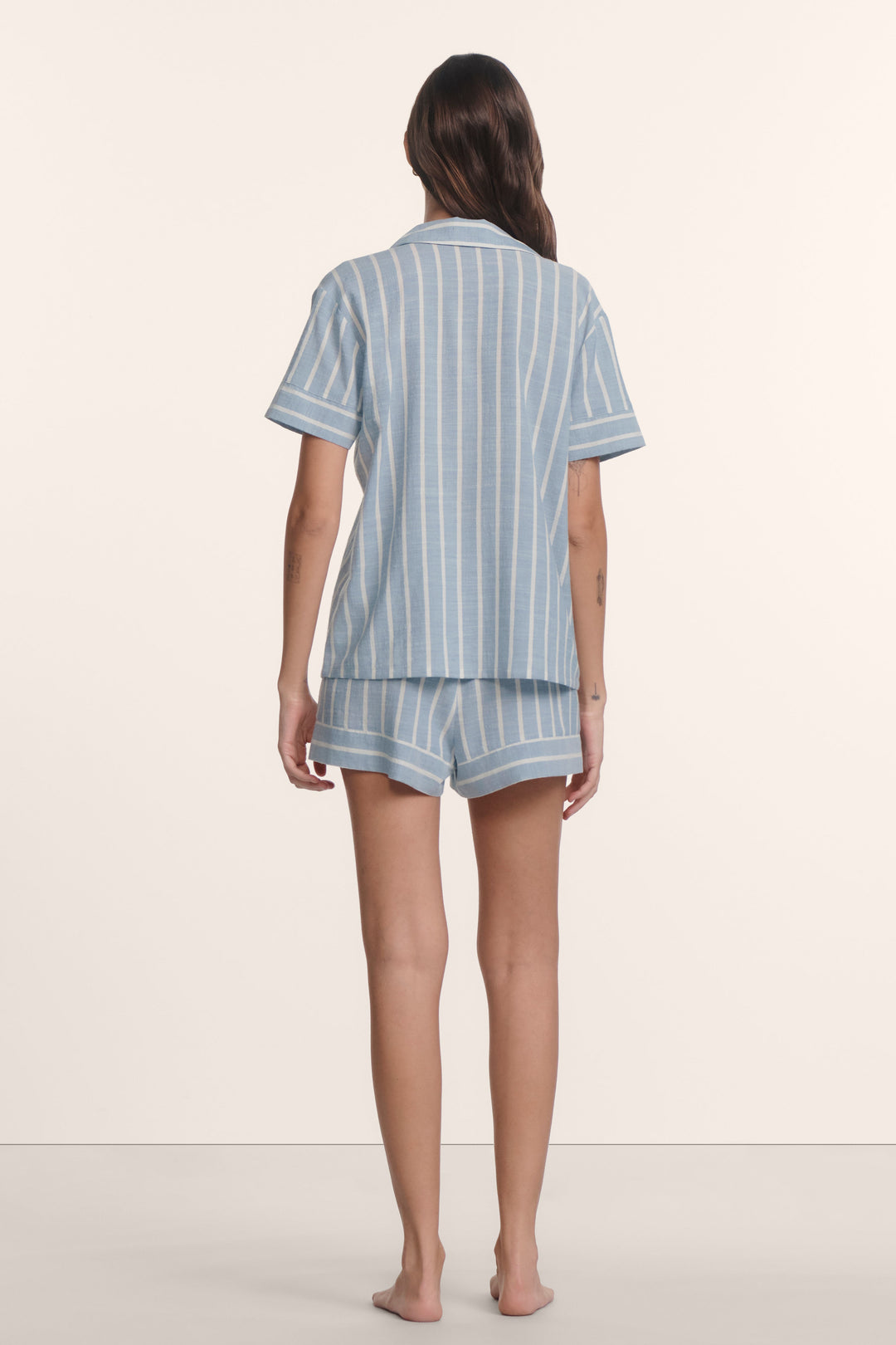 Woman wearing an eberjey blue and white striped nautico pajama set. Short sleeve boxy top with matching shorts
