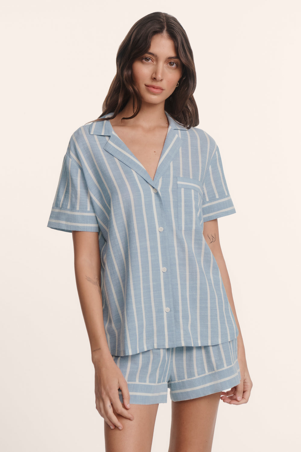 Woman wearing an eberjey blue and white striped nautico pajama set. Short sleeve boxy top with matching shorts