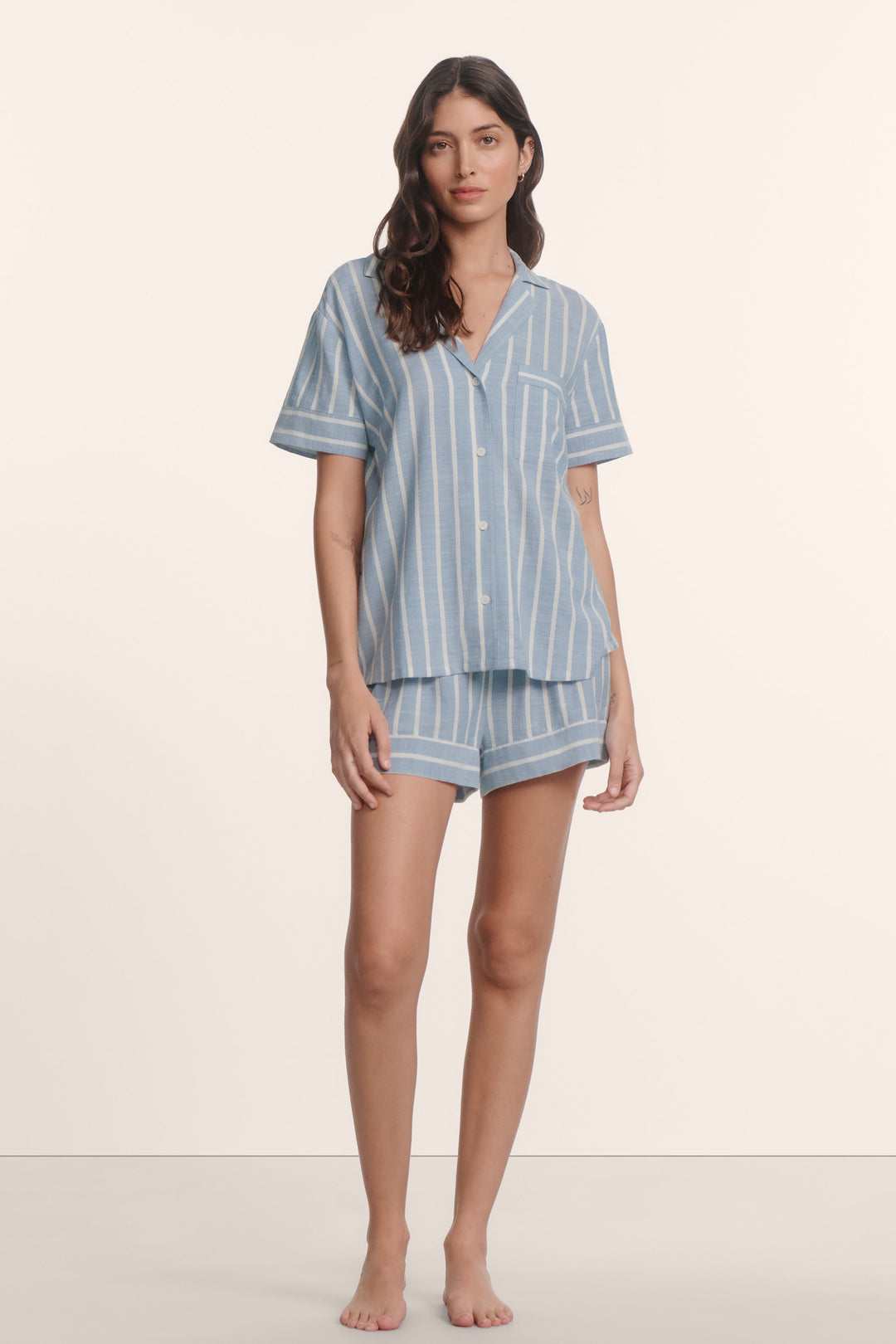 Woman wearing an eberjey blue and white striped nautico pajama set. Short sleeve boxy top with matching shorts