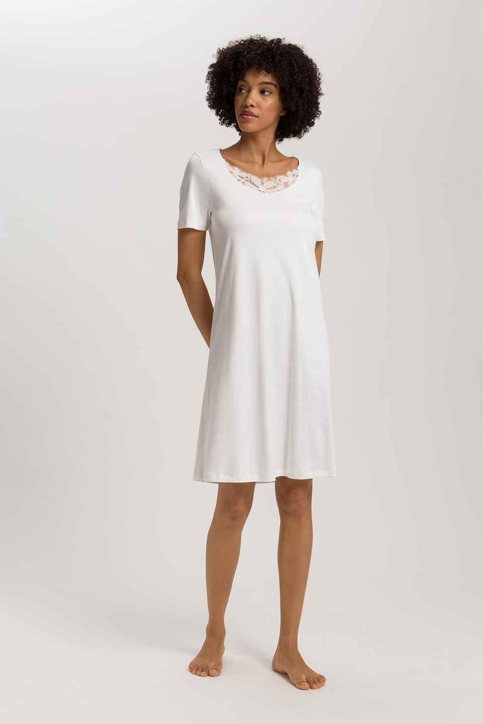 Woman wearing a white nightgown against a plain background