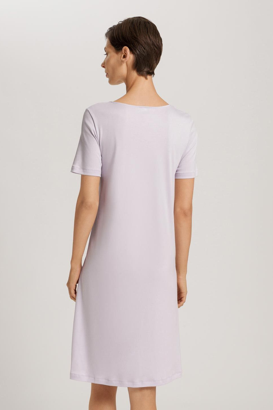 Woman wearing a light purple dress against a plain background