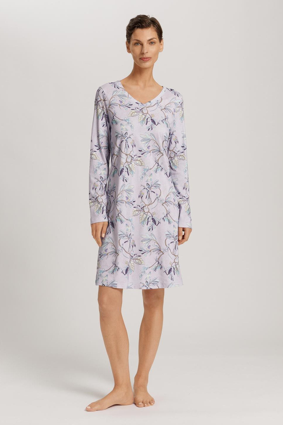 Woman wearing a floral patterned nightshirt on a plain background